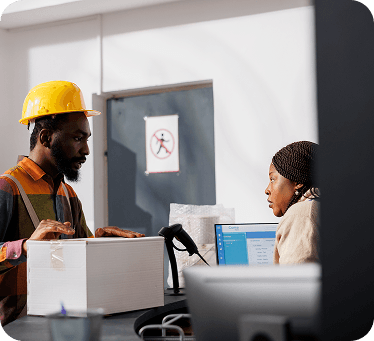 Two workers at a counter reviewing a system